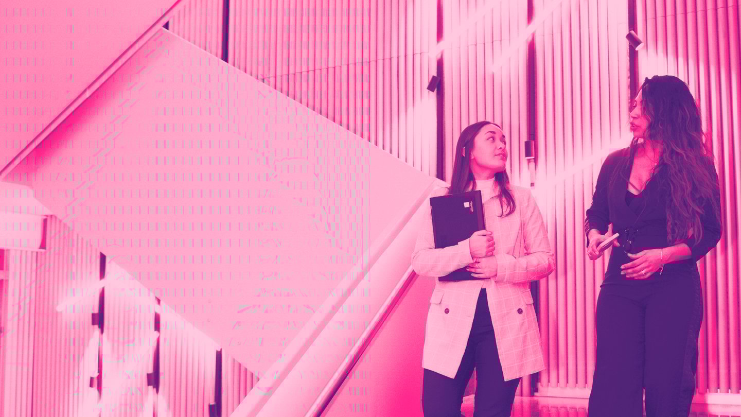 Two young women walk down a flight of stairs.
