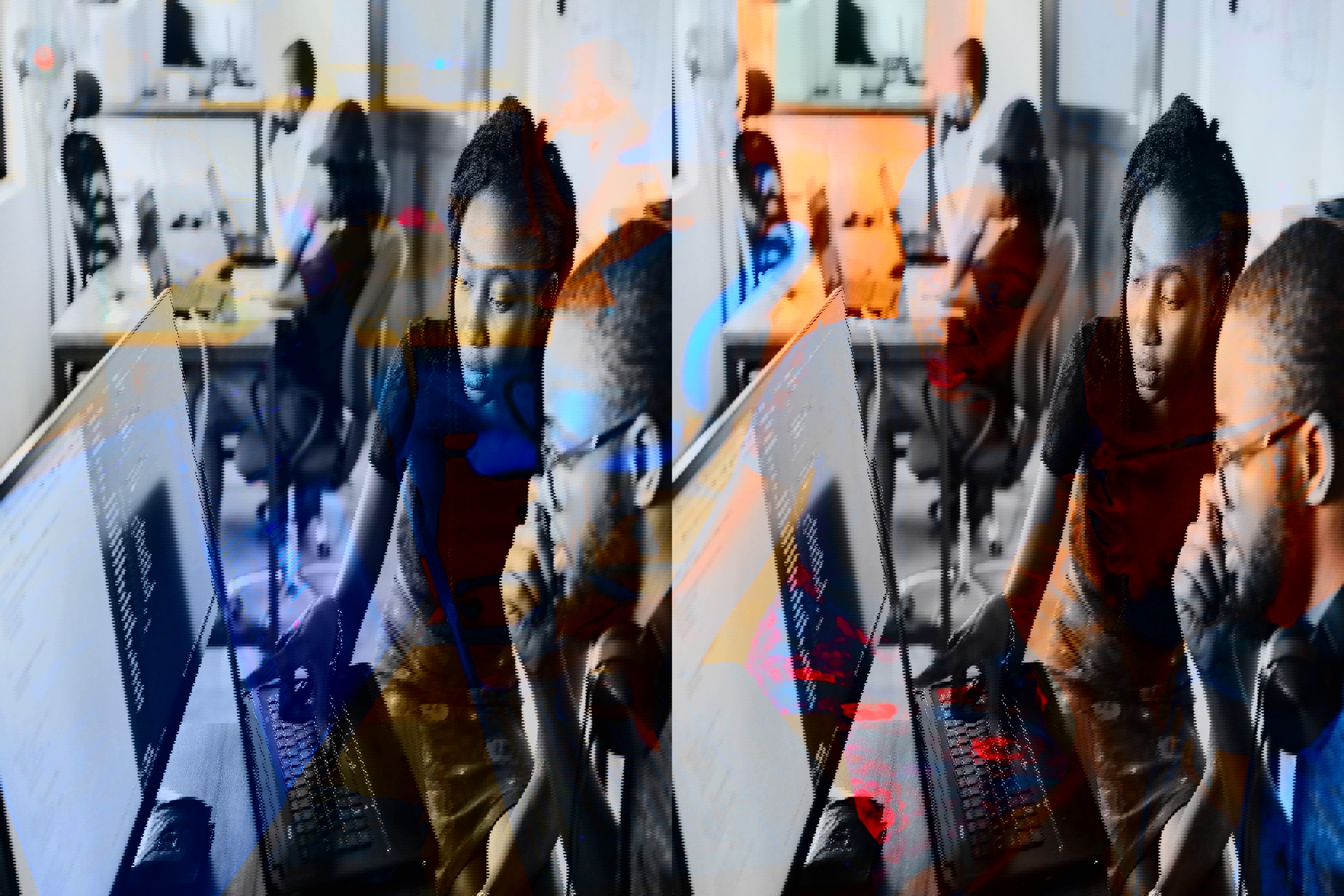 Two people sitting at a computer screen and thinking