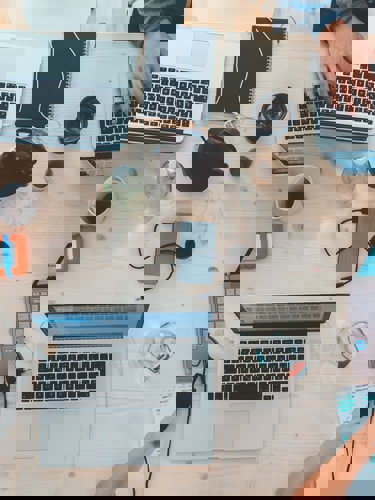 A desk filled with computers, cables, and people working. Gives a wonderfully messy feeling